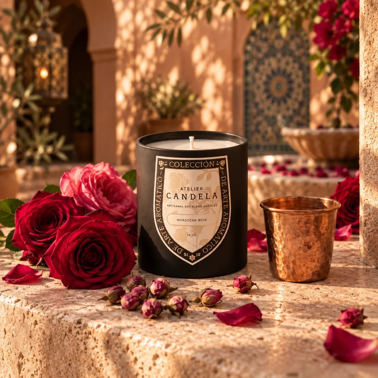 Moroccan Rose 14 oz artisanal soy candle by Atelier Candela in a Marrakesh riad courtyard with roses and a copper cup