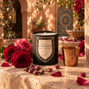 Moroccan Rose 14 oz artisanal soy candle by Atelier Candela in a Marrakesh riad courtyard with roses and a copper cup
